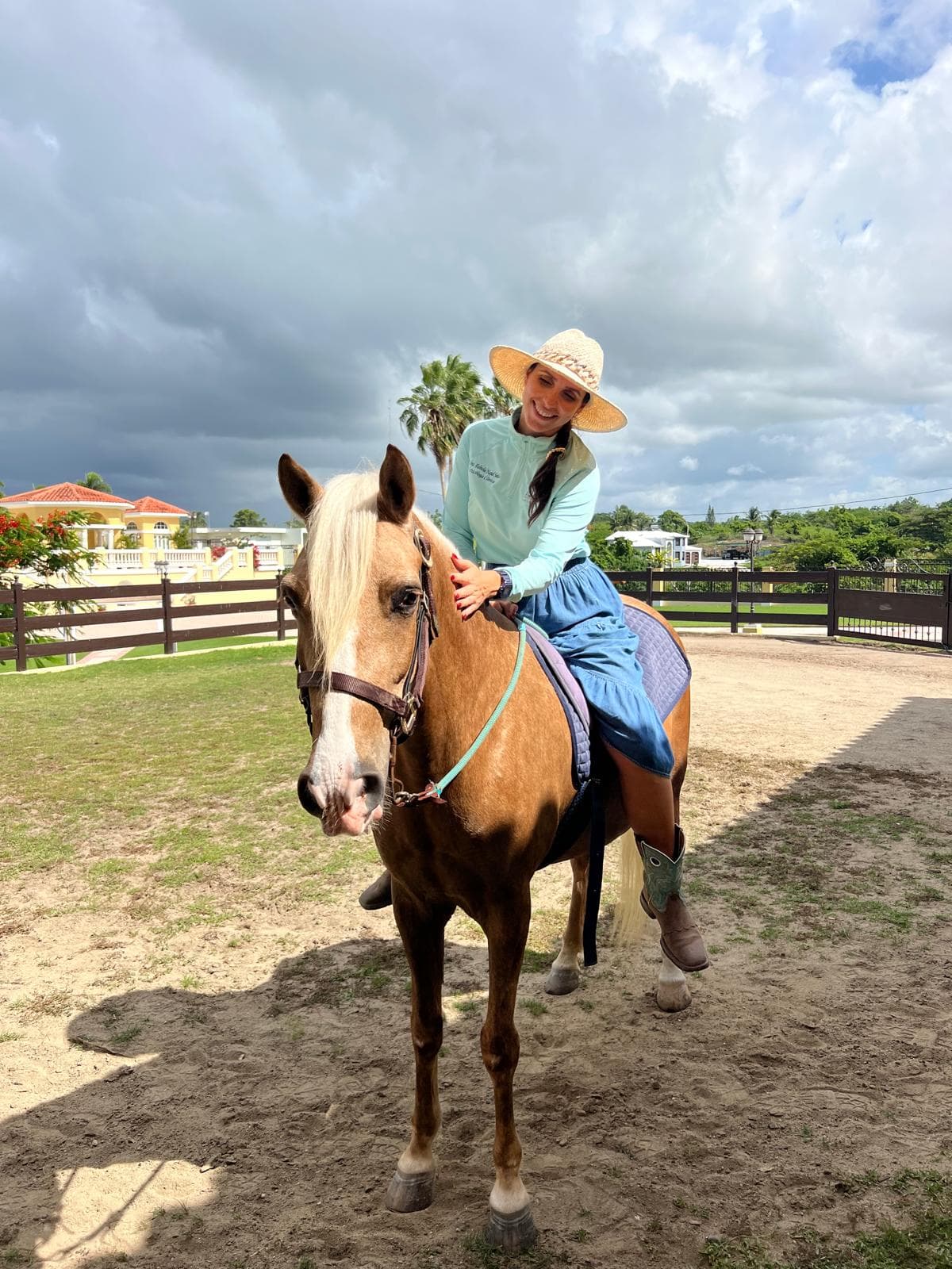 Adulta montando un caballo palomino en el picadero de Equilibrio