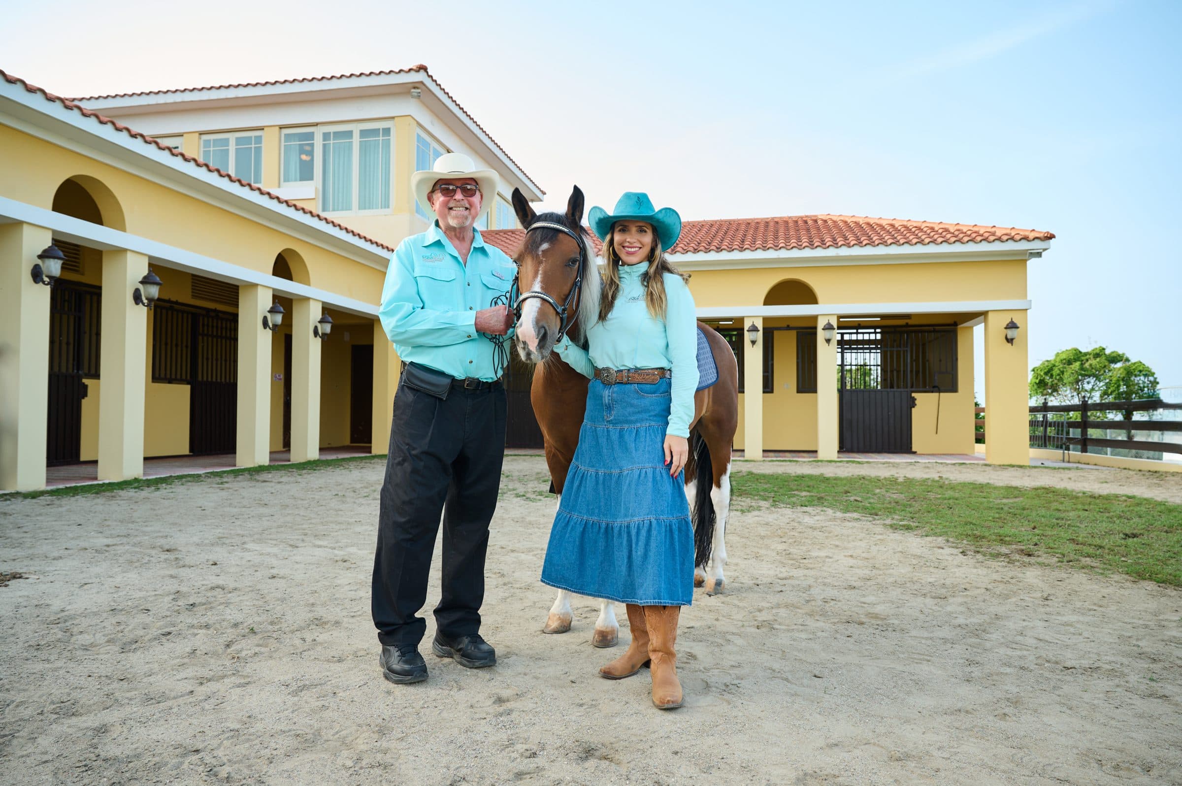 Dos profesionales del equipo junto a un caballo en el patio de las caballerizas